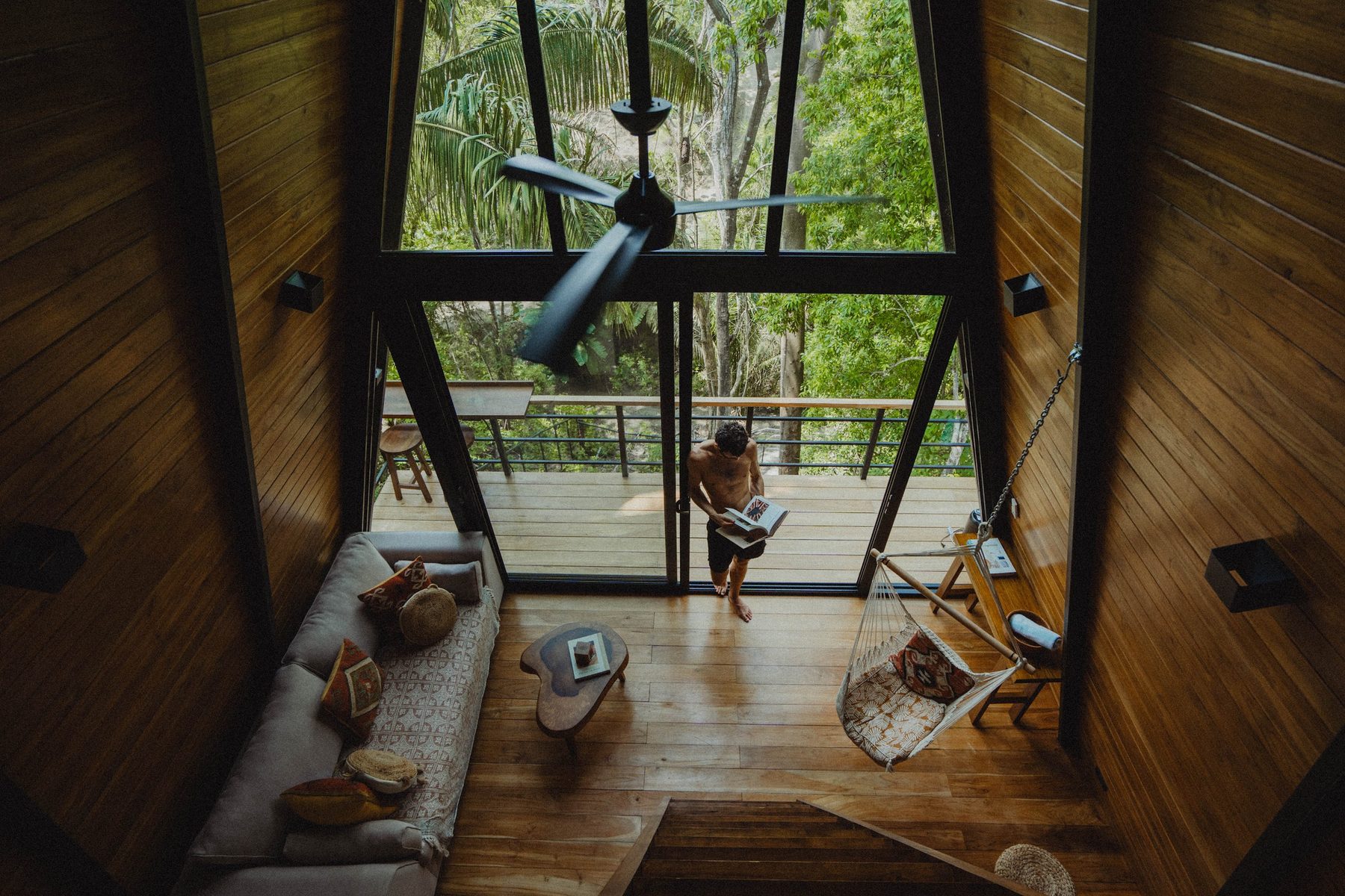 Aerial yoga in a glass-walled studio deep in the jungle